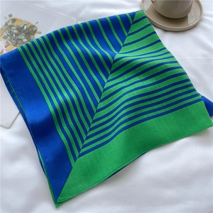 Macro detail of herringbone texture on blue and green striped square silk scarf