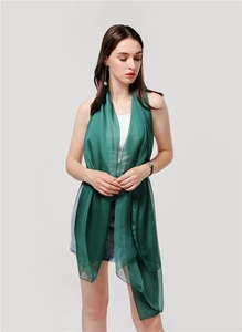 Dettaglio di scialle in chiffon verde scuro con elegante texture semitrasparente