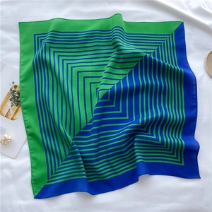 Detail of blue and emerald green striped silk scarf with smooth texture and geometric pattern