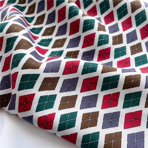 Détail du motif géométrique en losange sur un foulard en soie avec des blocs de couleurs
