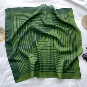 Detail of soft dark green striped scarf with a silky finish and geometric patterns