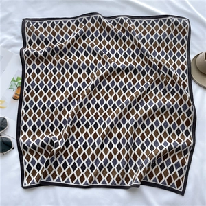 Mise à plat d'un foulard en soie à carreaux avec tasse de café et lunettes pour un look chic