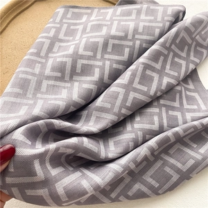 Detail shot of the lightweight herringbone silk-like scarf with geometric patterns