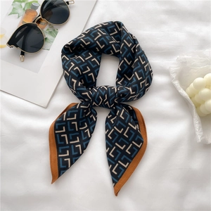 Elegant geometric patterned navy silk scarf with orange border on a stylish white background