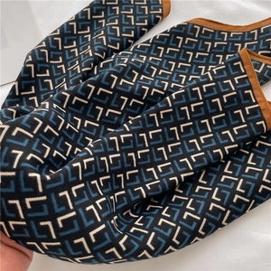 Detailed close-up of herringbone pattern silk scarf showing soft knit texture and brown edges