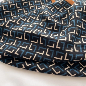 Detailed view of herringbone velvet scarf with geometric blue and black patterns