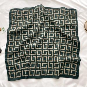 Deep green square silk scarf with gold interlocking geometric patterns on white fabric