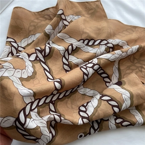 Détail d'un foulard en soie avec motif de cordes et plis élégants en tissu brillant