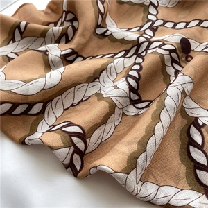 Détail du motif de chaîne vintage sur foulard en soie lisse de couleur kaki et marron