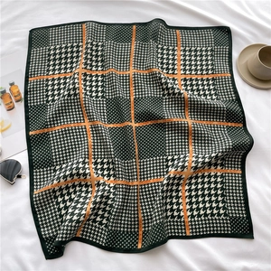 Détail d'un foulard en soie avec motif pied-de-poule et lignes orange fines