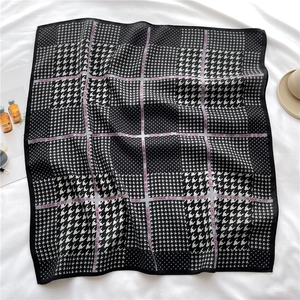 Détail d'un foulard en soie à motif pied-de-poule classique avec bordure noire élégante