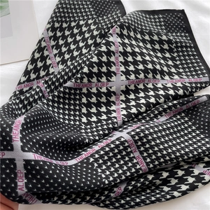 Détail d'un foulard en soie à motif pied-de-poule avec des accents de rayures violettes