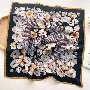 Detailed close-up of floral zebra print silk scarf with refined yellow rolled edges
