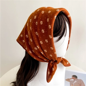 Detail of caramel silk scarf with white leaf pattern worn as a vintage style headscarf