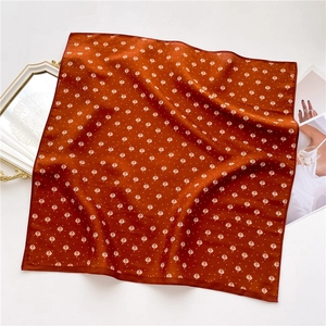Caramel satin square scarf with white leaf print on a white background with props