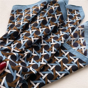 Detail of colorful geometric woven pattern and silk texture on soft square scarf