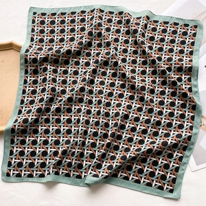 Detail of geometric woven silk scarf featuring black, white, and mint green borders