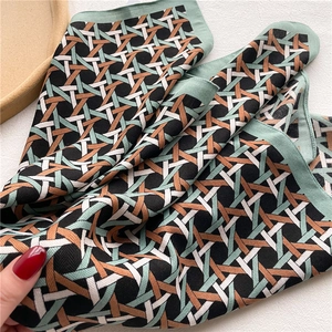 Detailed view of the vintage geometric pattern and twill texture on a soft silk scarf