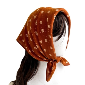 Brown orange leaf print silk scarf tied on a mannequin head in vintage style