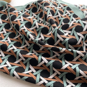 Detailed macro shot of geometric twill woven fabric in mint green and caramel colors