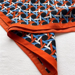 Macro detail of geometric lattice pattern on orange and blue faux velvet square scarf