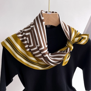 Detail of a geometric patterned silk scarf with mustard yellow borders and black polka dots