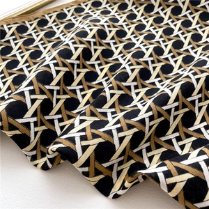 Close-up of geometric woven pattern on silk scarf with black and beige textures