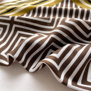 Close-up of geometric pattern scarf showing fine knit texture and striped edges