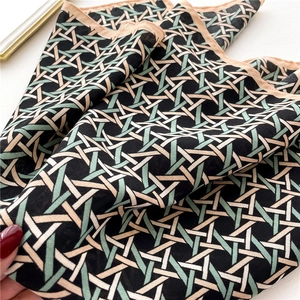 Detailed view of geometric woven pattern fabric with black, beige, and green stripes
