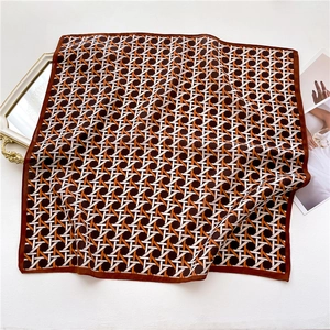 Flat lay of geometric plaid pattern silk square scarf with vintage mirror and magazine