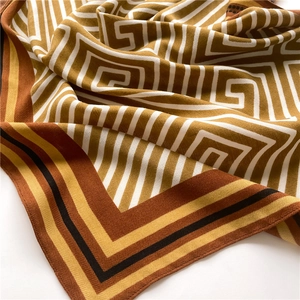 Detailed view of geometric pattern silk scarf with twill weave and striped edges