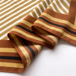 Detail of herringbone weave texture on a geometric striped scarf in warm earthy tones