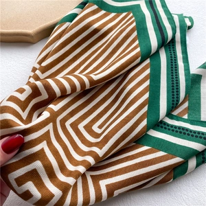 Detail of geometric pattern scarf with silk texture in brown, white and green trim