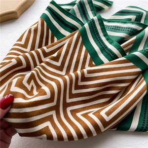 Detailed shot of silk scarf with geometric chevron pattern and scalloped dot borders