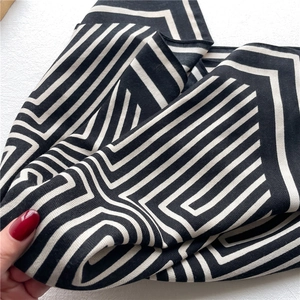 Close-up of black and white geometric herringbone pattern on soft lightweight silk scarf