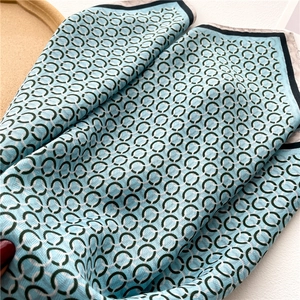 Détail d'un foulard en soie de luxe avec motifs de chaînes bleues et bords contrastés