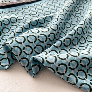 Détail d'un foulard bleu ciel à motif chevrons avec des cercles géométriques verts