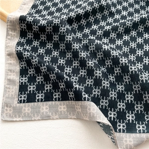 Macro detail of the double-sided silk scarf with geometric pattern and smooth texture