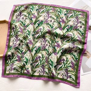 Detail of floral pattern on square silk scarf with purple and green leaf motifs