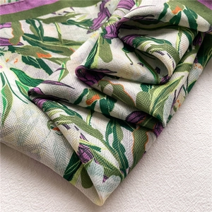 Macro view of floral silk scarf featuring linen texture and delicate green plant pattern