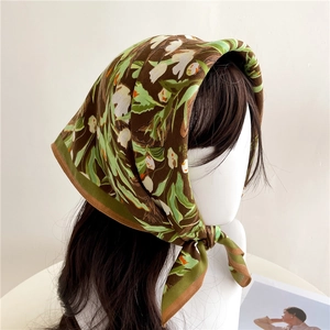 Floral print square headscarf in dark brown with green leaves worn on a model