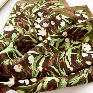 Close-up of silk scarf showing vintage floral patterns and twill weave texture