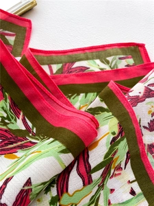 Detail of floral printed scarf showing twill texture and tropical leaf pattern