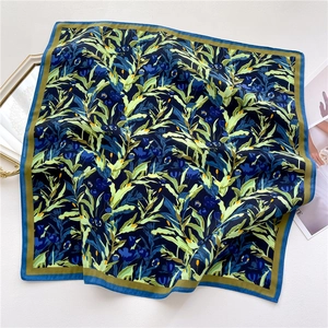 Detail of navy blue floral square scarf with smooth silk-like texture and plant pattern