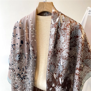 Detailed view of large vintage paisley print silk scarf with daisy patterns and soft drape