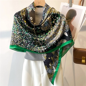 Detail of printed silk scarf with floral daisy pattern and bright green edges