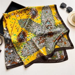 Close-up of vintage yellow floral satin scarf with brown border and silky texture