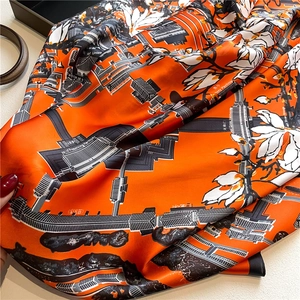 Detail of silk scarf with orange Chinese architecture and magnolia floral pattern