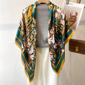 Elegant floral silk scarf in dark green and yellow, styled as an oversize shawl wrap