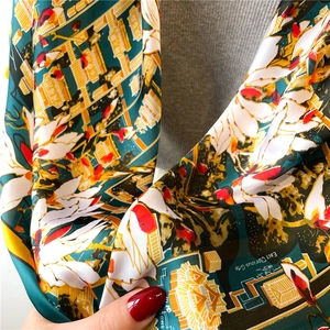 Close-up of silk-like satin shawl showing classical architecture print and luxurious texture